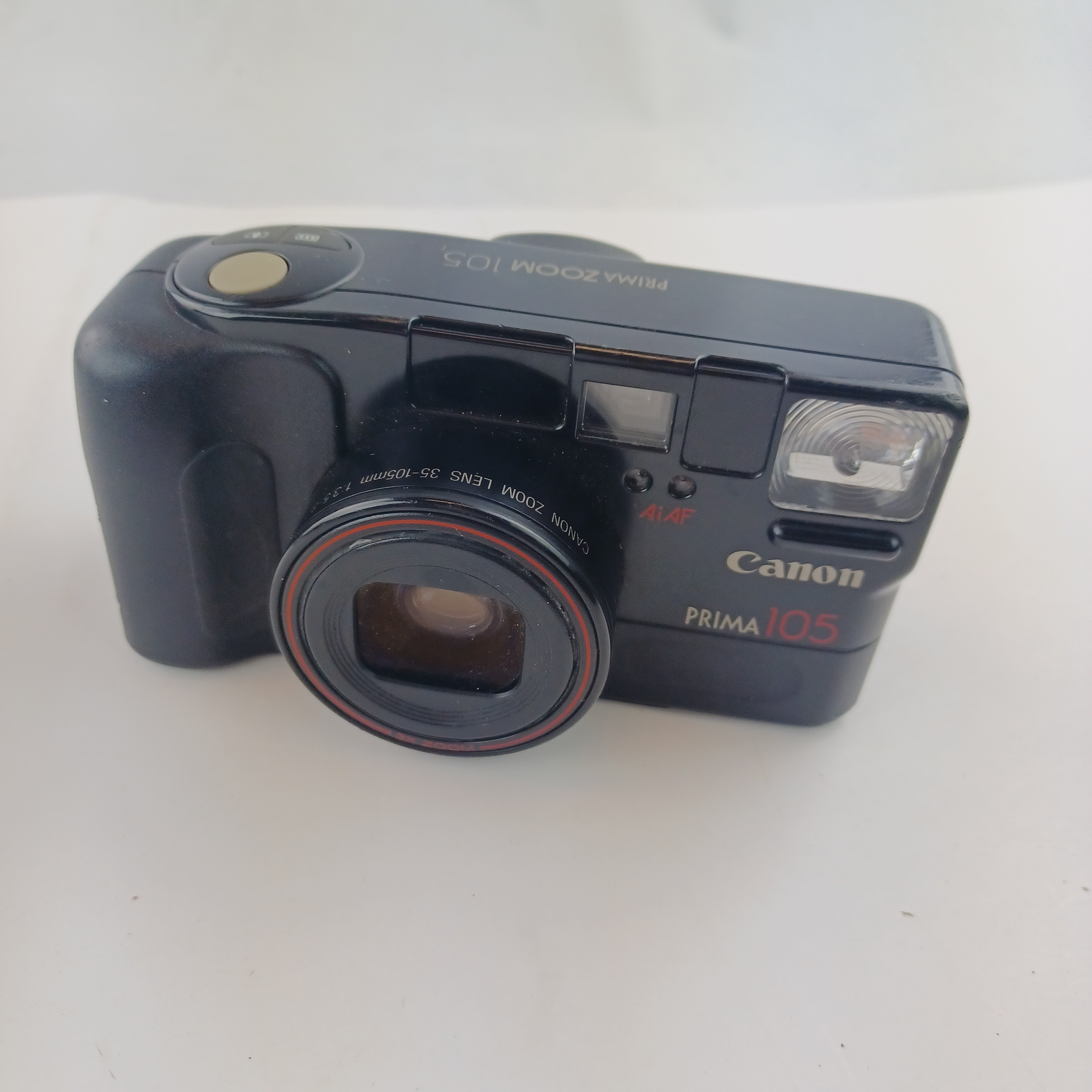 Voir photo 2 de Appareil photo Canon Prima 105 avec batterie lithium KL2CR5 sans chargeur, pellicule dedans, zoom 35-105, flash intégré, mode yeux rouges, retardateur et rafale, avec pochette et mode d'emploi Appareil photo Canon Prima 105 avec batterie lithium KL2CR5 sans chargeur, pellicule dedans, zoom 35-105, flash intégré, mode yeux rouges, retardateur et rafale, avec pochette et mode d'emploi Très bon état reconditionné photo 2