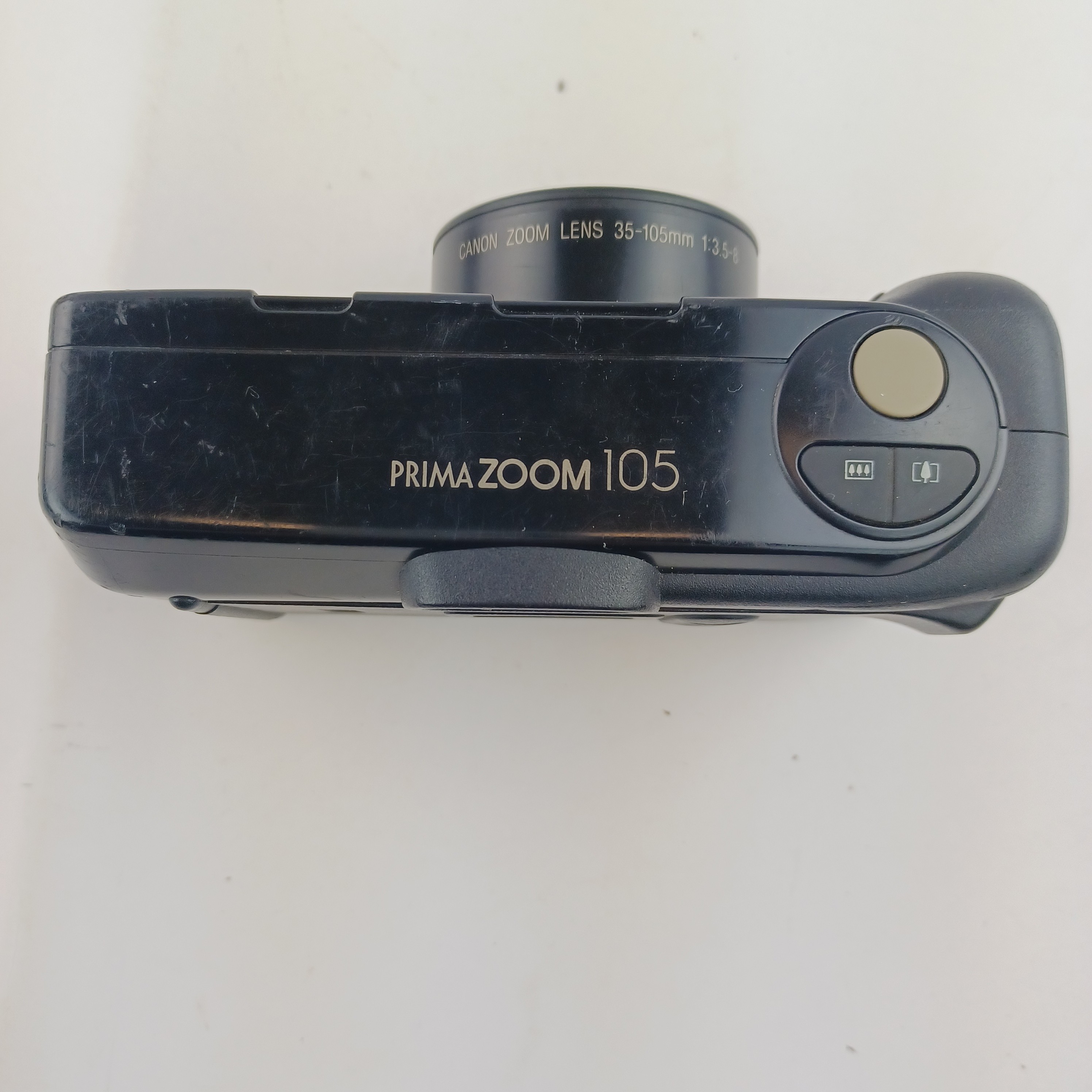 Voir photo 6 de Appareil photo Canon Prima 105 avec batterie lithium KL2CR5 sans chargeur, pellicule dedans, zoom 35-105, flash intégré, mode yeux rouges, retardateur et rafale, avec pochette et mode d'emploi Appareil photo Canon Prima 105 avec batterie lithium KL2CR5 sans chargeur, pellicule dedans, zoom 35-105, flash intégré, mode yeux rouges, retardateur et rafale, avec pochette et mode d'emploi Très bon état reconditionné photo 6