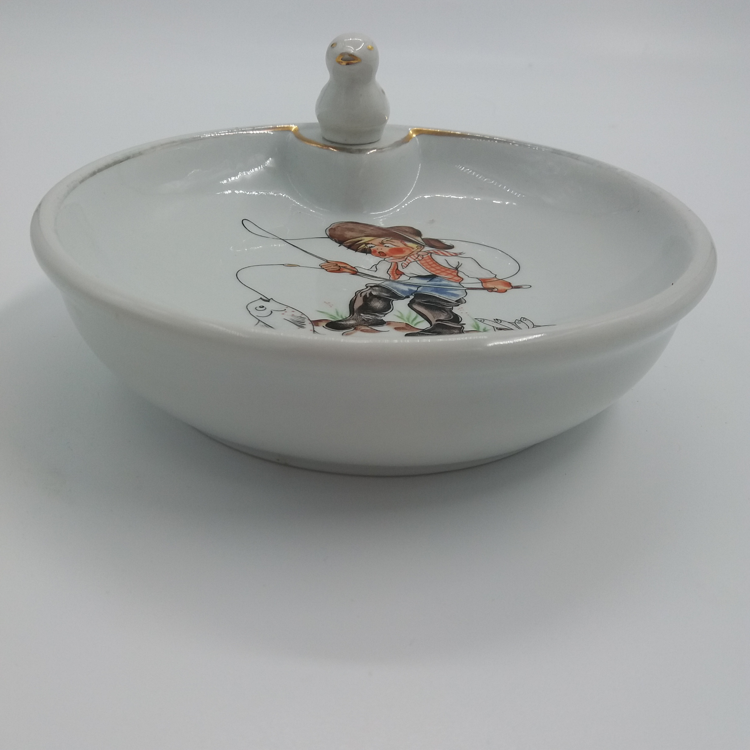 Voir photo 3 de Assiette à bouillie ancienne. Porcelaine. Décor de jeune pêcheur et poisson. Petit canard en guise de bouchon. Signée CNP Porcelaine de la compagnie nationale. Assiette à bouillie ancienne. Porcelaine. Décor de jeune pêcheur et poisson. Petit canard en guise de bouchon. Signée CNP Porcelaine de la compagnie nationale. Très bon état reconditionné photo 3
