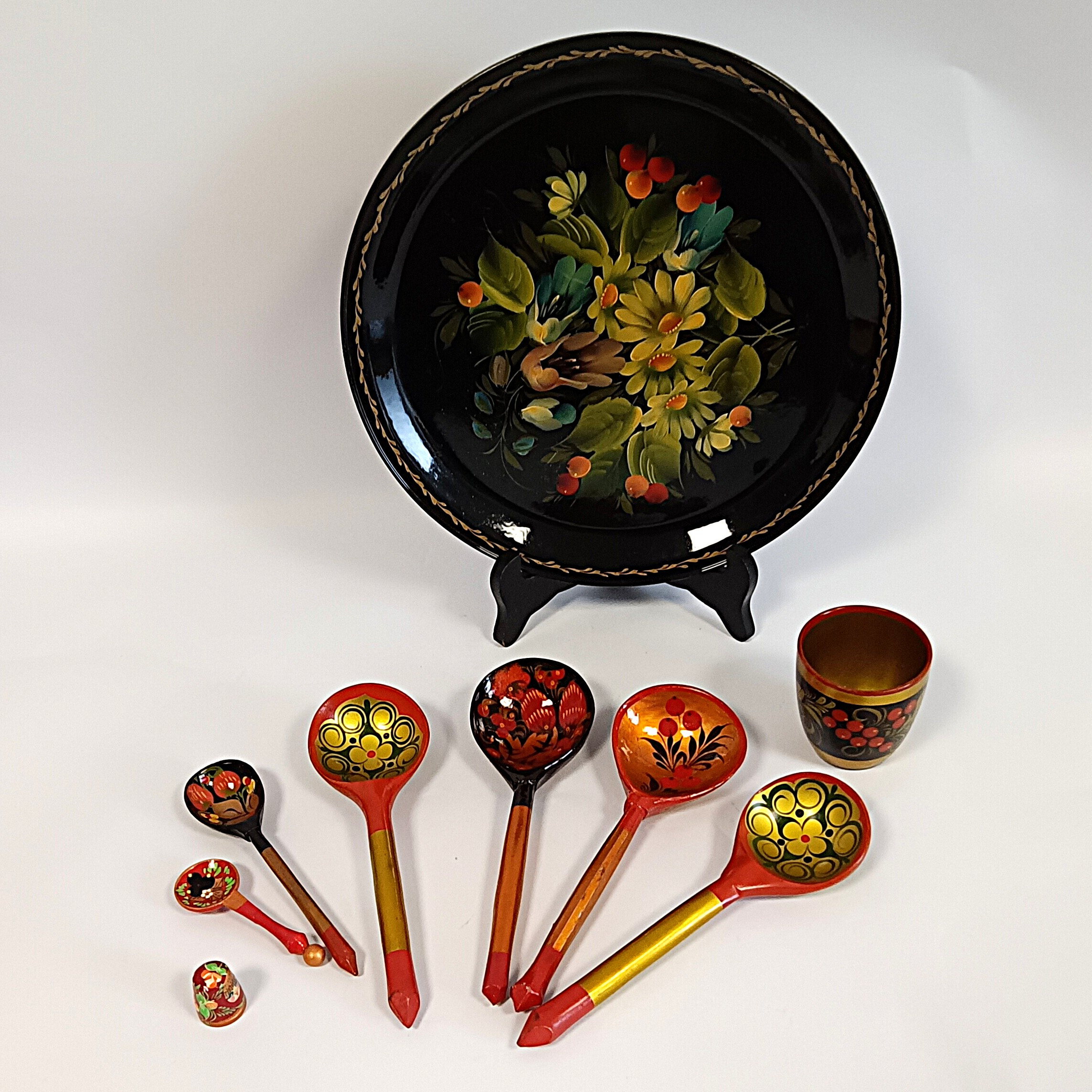 Voir photo 2 de Assiette décorative russe Khokhloma Ø 27 cm et lot d’objets en bois peint avec cuillères, dé et gobelet Assiette décorative russe Khokhloma Ø 27 cm et lot d’objets en bois peint avec cuillères, dé et gobelet Bon état reconditionné photo 2