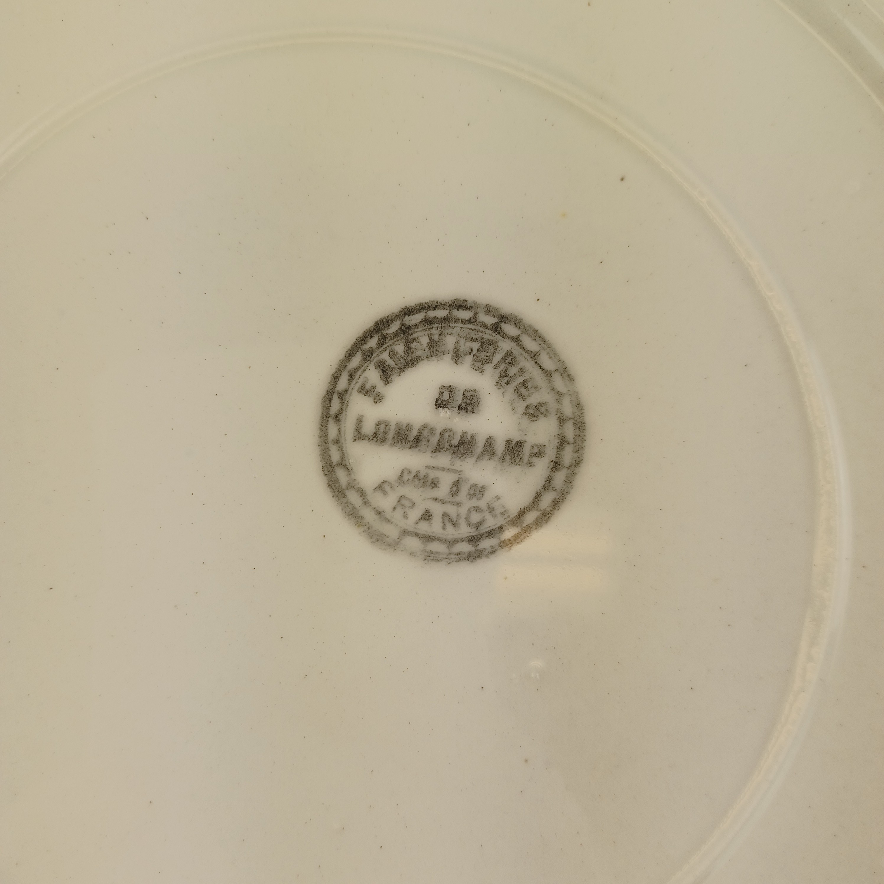 Voir photo 4 de Assiette plate de la faïencerie de Longchamp datant d'après-guerre de 27 cm de diamètre Assiette plate de la faïencerie de Longchamp datant d'après-guerre de 27 cm de diamètre Très bon état reconditionné photo 4