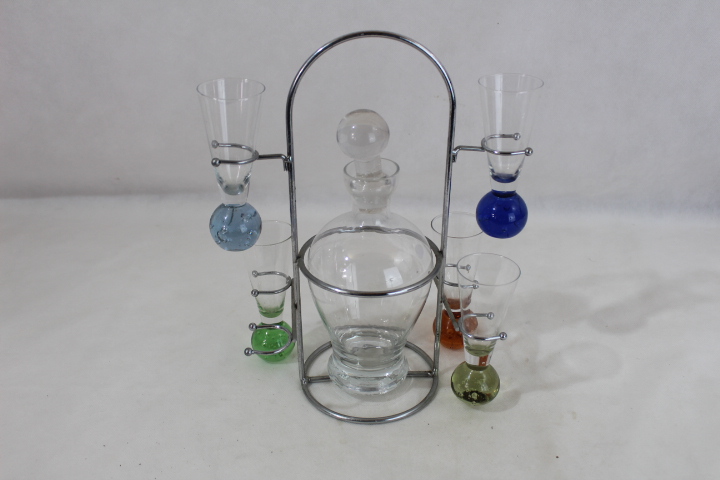 Carafe à liqueur plus 5 verres sur socle en acier Très bon état - 25,00 € Carafe à liqueur plus 5 verres sur socle en acier Très bon état reconditionné disponible sur Label Emmaüs