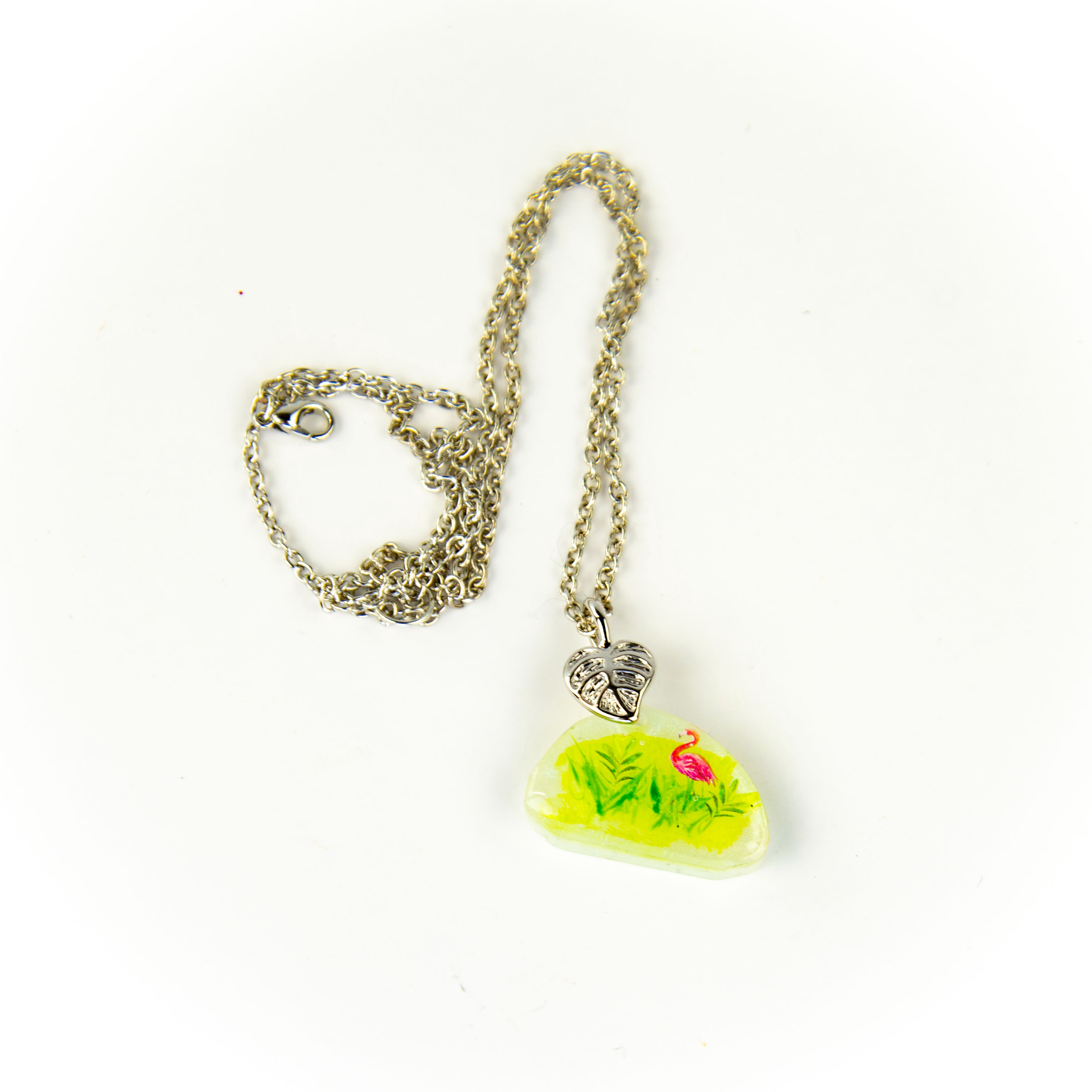 Voir photo 2 de Collier en résine époxy blanc à motif d'un flamand rose dans l'herbe avec accroche en forme de feuille et chaîne en métal Collier en résine époxy blanc à motif d'un flamand rose dans l'herbe avec accroche en forme de feuille et chaîne en métal Parfait état reconditionné photo 2