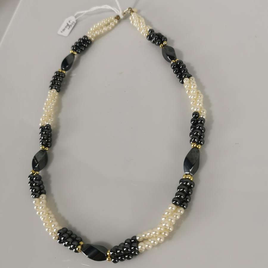 Collier torsadé fausses perles blanches et hématite Bon état - 12,00 € Collier torsadé fausses perles blanches et hématite Bon état reconditionné disponible sur Label Emmaüs