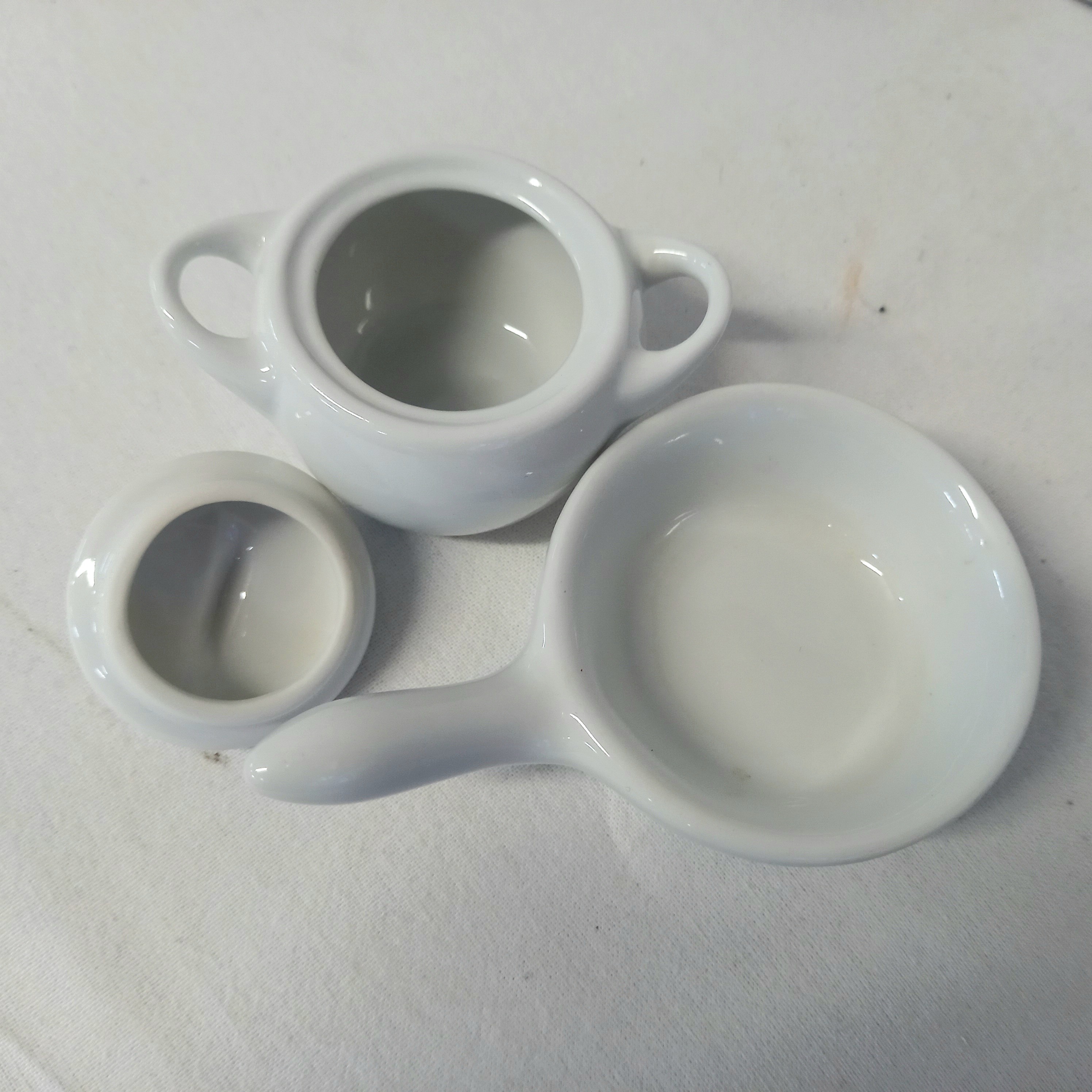 Voir photo 4 de Dinette en porcelaine - quatre tasses et quatre soucoupes, un sucrier, une casserole, une verseuse à lait, une cafetière Dinette en porcelaine - quatre tasses et quatre soucoupes, un sucrier, une casserole, une verseuse à lait, une cafetière Très bon état reconditionné photo 4