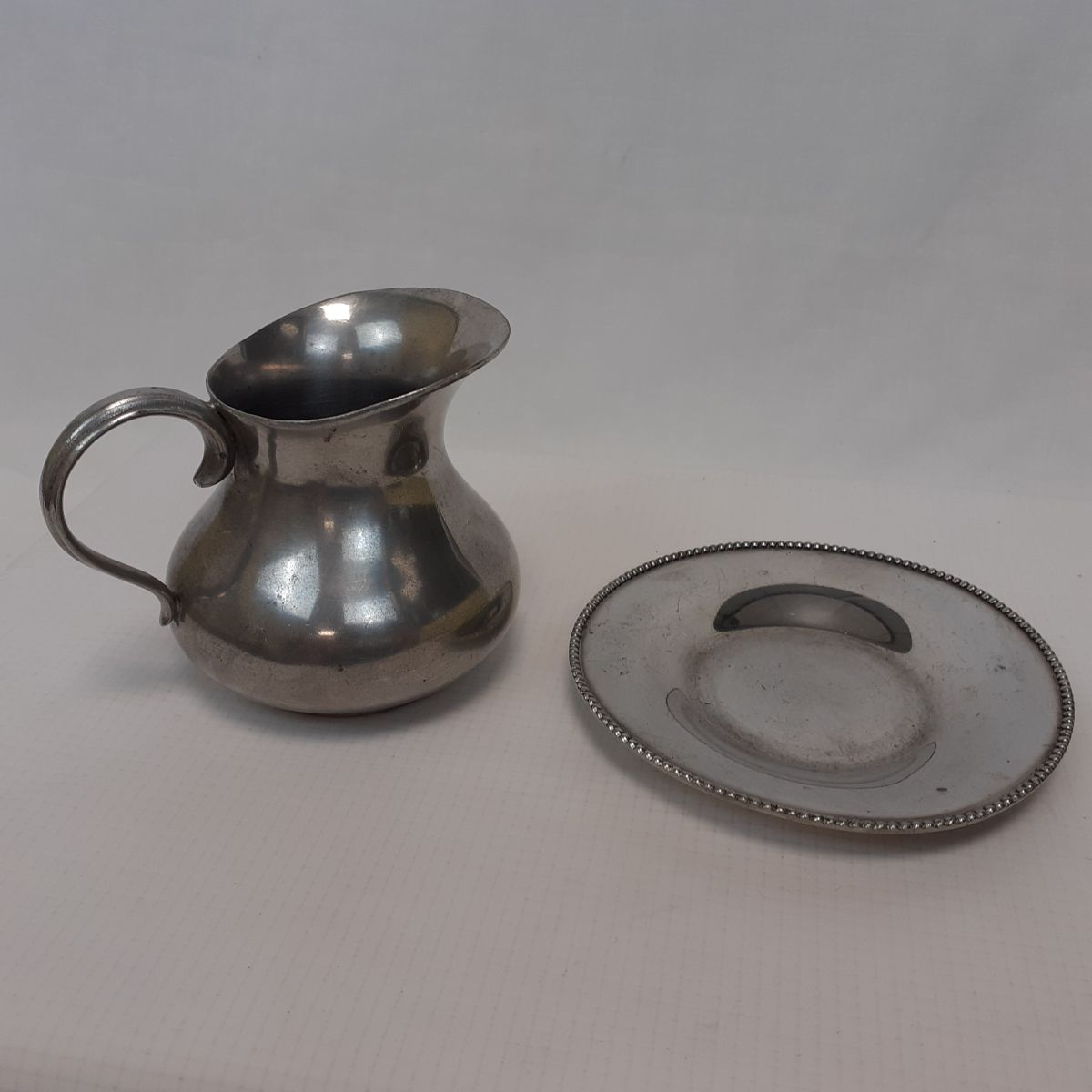 Voir photo 2 de Ensemble petit pot à lait + soucoupe - Etain anglais 95% Ensemble petit pot à lait + soucoupe - Etain anglais 95% Bon état reconditionné photo 2