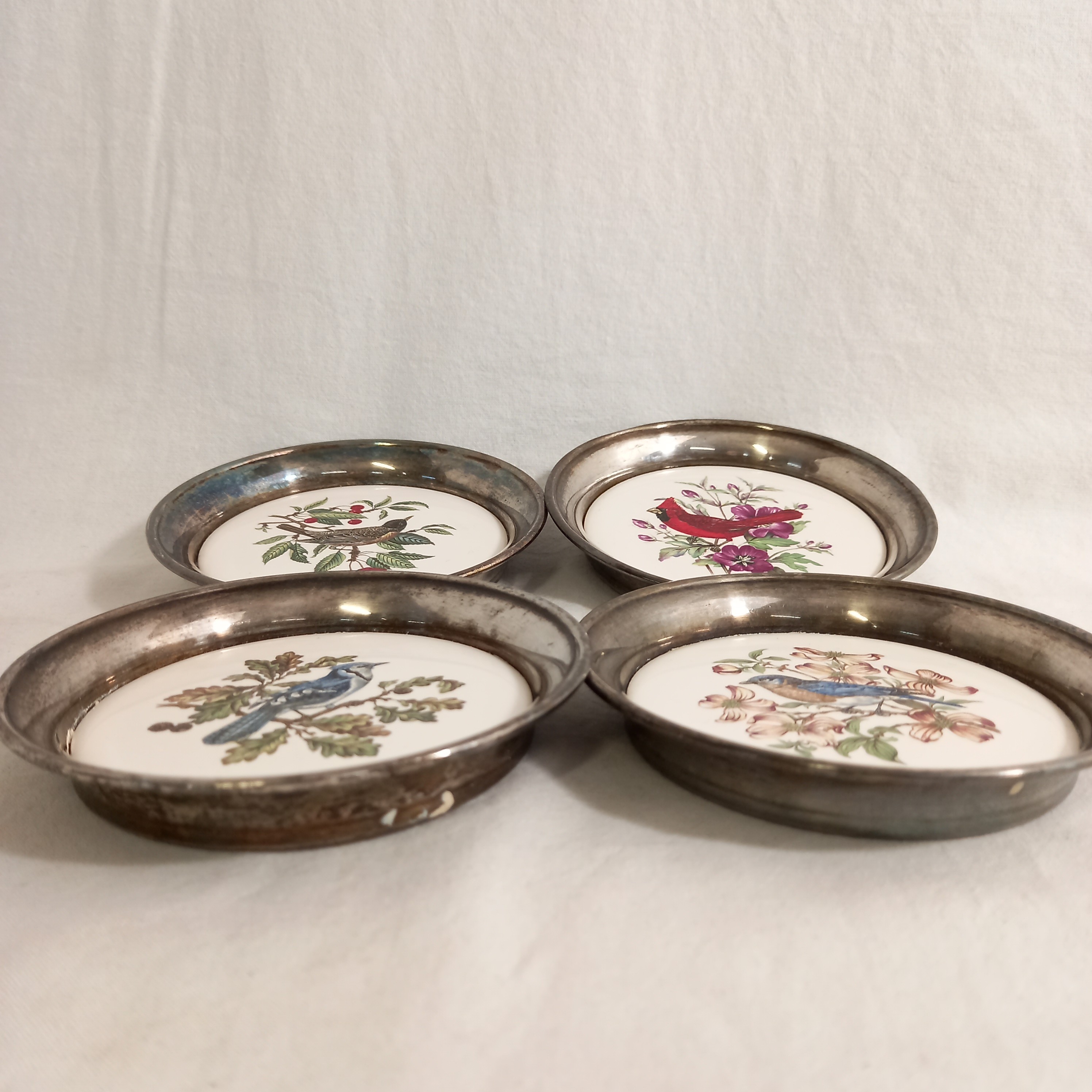Voir photo 2 de Lot de quatre dessous vintage de verre ou de bouteille, en métal et céramique, avec des oiseaux pour motifs Lot de quatre dessous vintage de verre ou de bouteille, en métal et céramique, avec des oiseaux pour motifs Bon état reconditionné photo 2