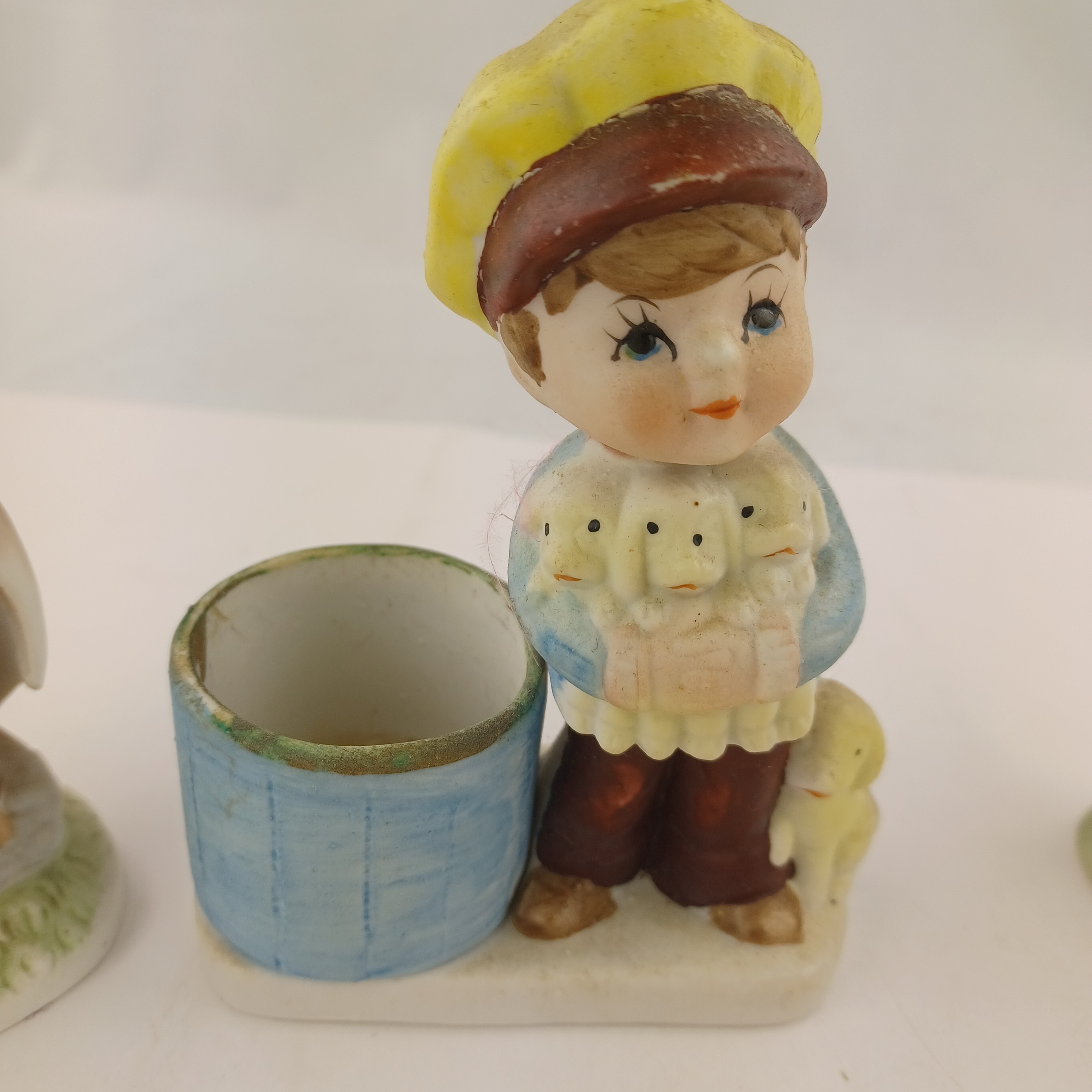 Voir photo 4 de Lot de trois statuettes de Corée en porcelaine biscuit une avec bougroir et jeune homme portant trois agneaux, une avec un jeune homme sur une pierre portant un parapluie et une avec un jeune garçon en salopette sur une barrière Lot de trois statuettes de Corée en porcelaine biscuit une avec bougroir et jeune homme portant trois agneaux, une avec un jeune homme sur une pierre portant un parapluie et une avec un jeune garçon en salopette sur une barrière Très bon état reconditionné photo 4