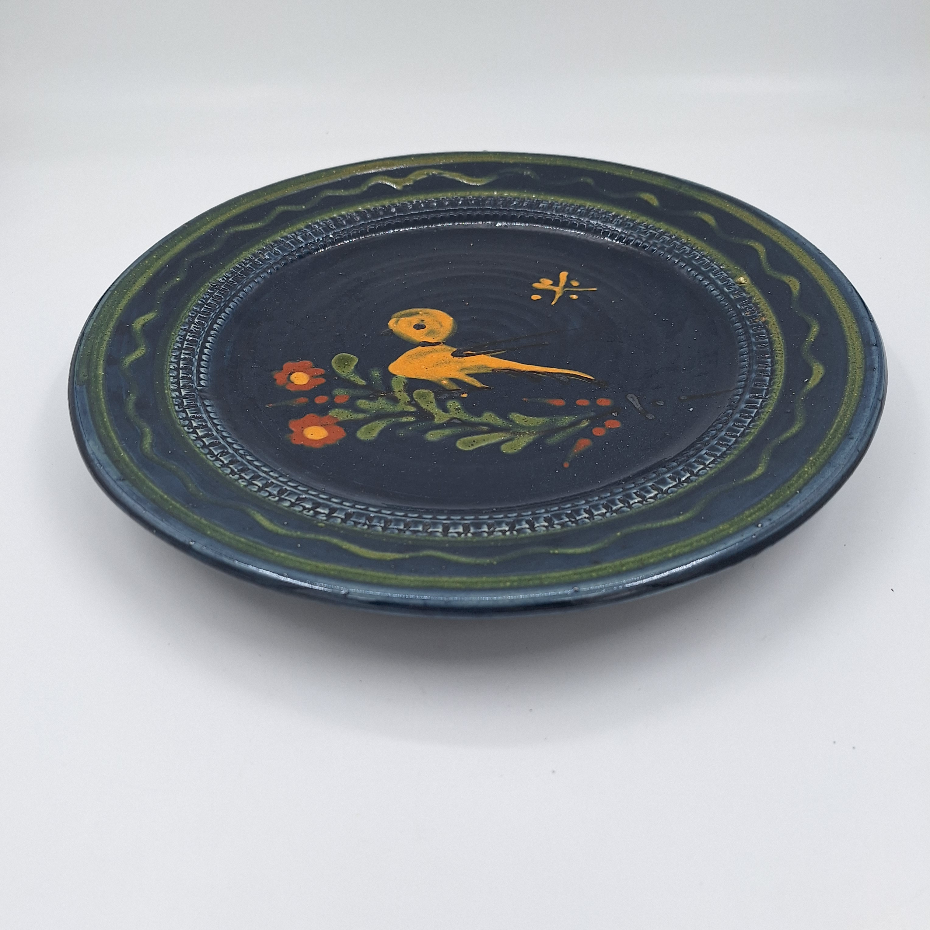 Voir photo 2 de Plat rond. Bleu nuit. Décor floral et oiseau. Céramique. Estampillé d’un décor sous la pièce. Plat rond. Bleu nuit. Décor floral et oiseau. Céramique. Estampillé d’un décor sous la pièce. Très bon état reconditionné photo 2