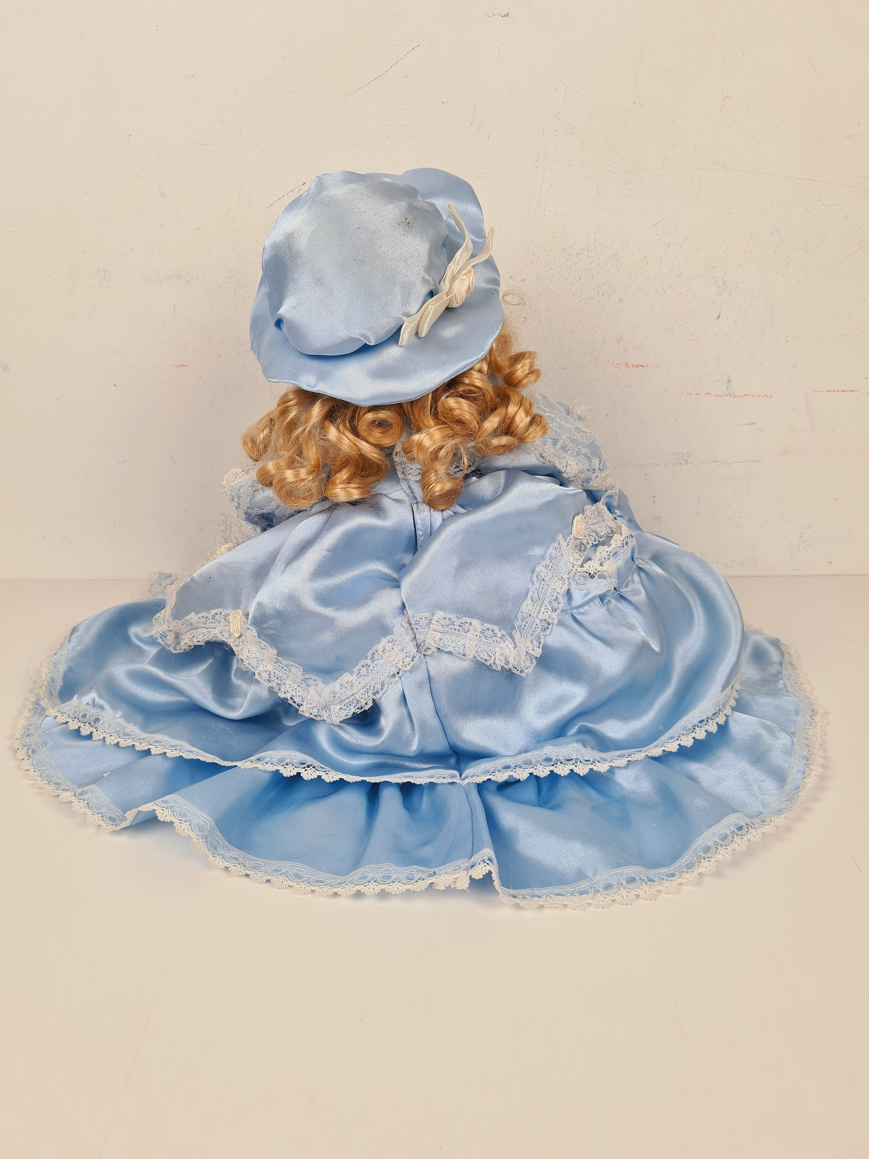 Voir photo 3 de Poupée - Poupée en porcelaine sur coussin avec une robe bleu - 33 cm Poupée - Poupée en porcelaine sur coussin avec une robe bleu - 33 cm Bon état reconditionné photo 3