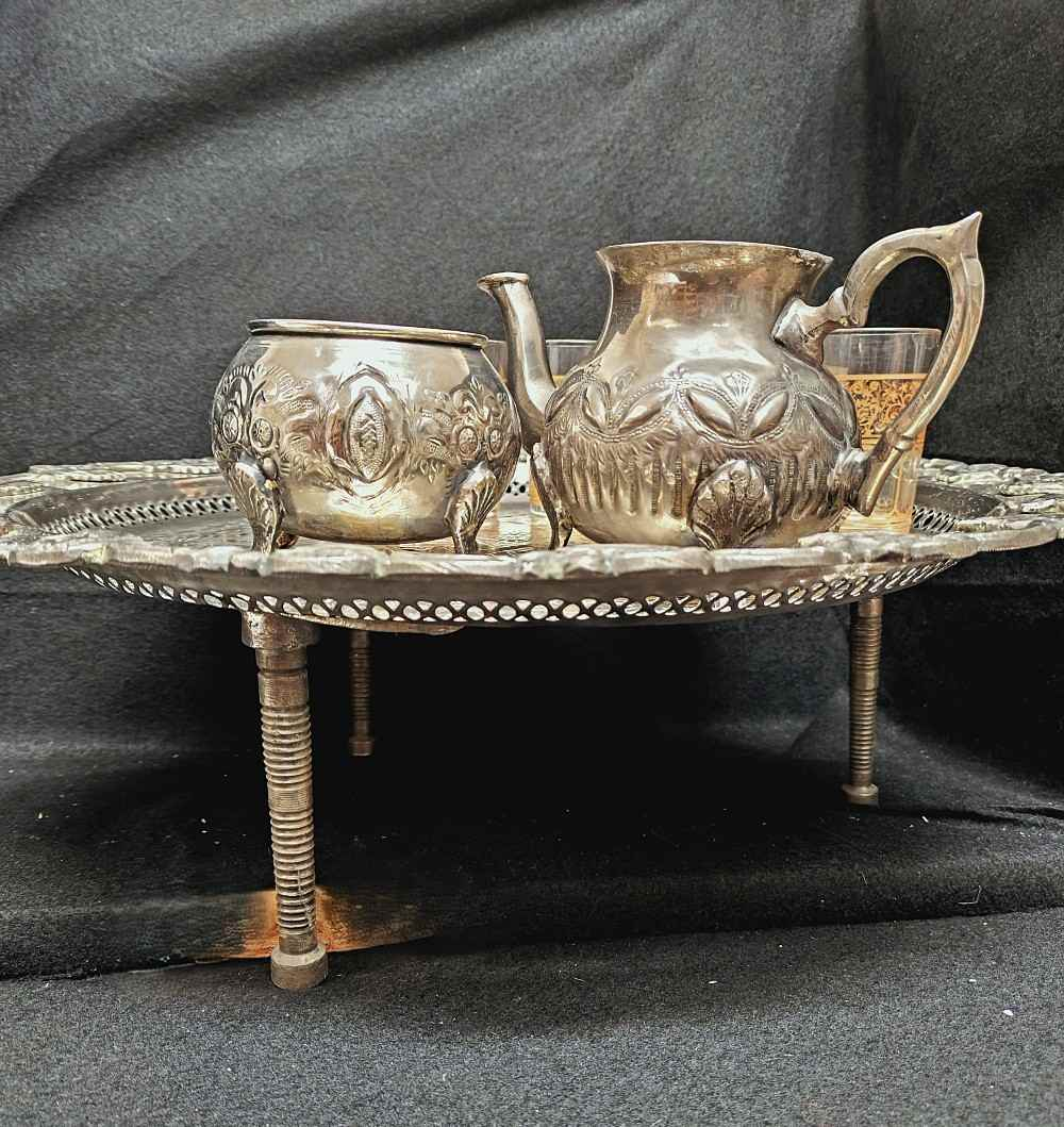 Voir photo 4 de Service à thé marocain, table à pied, 6 verres à thé, théière et sucrier en métal argenté. Service à thé marocain, table à pied, 6 verres à thé, théière et sucrier en métal argenté. Bon état reconditionné photo 4