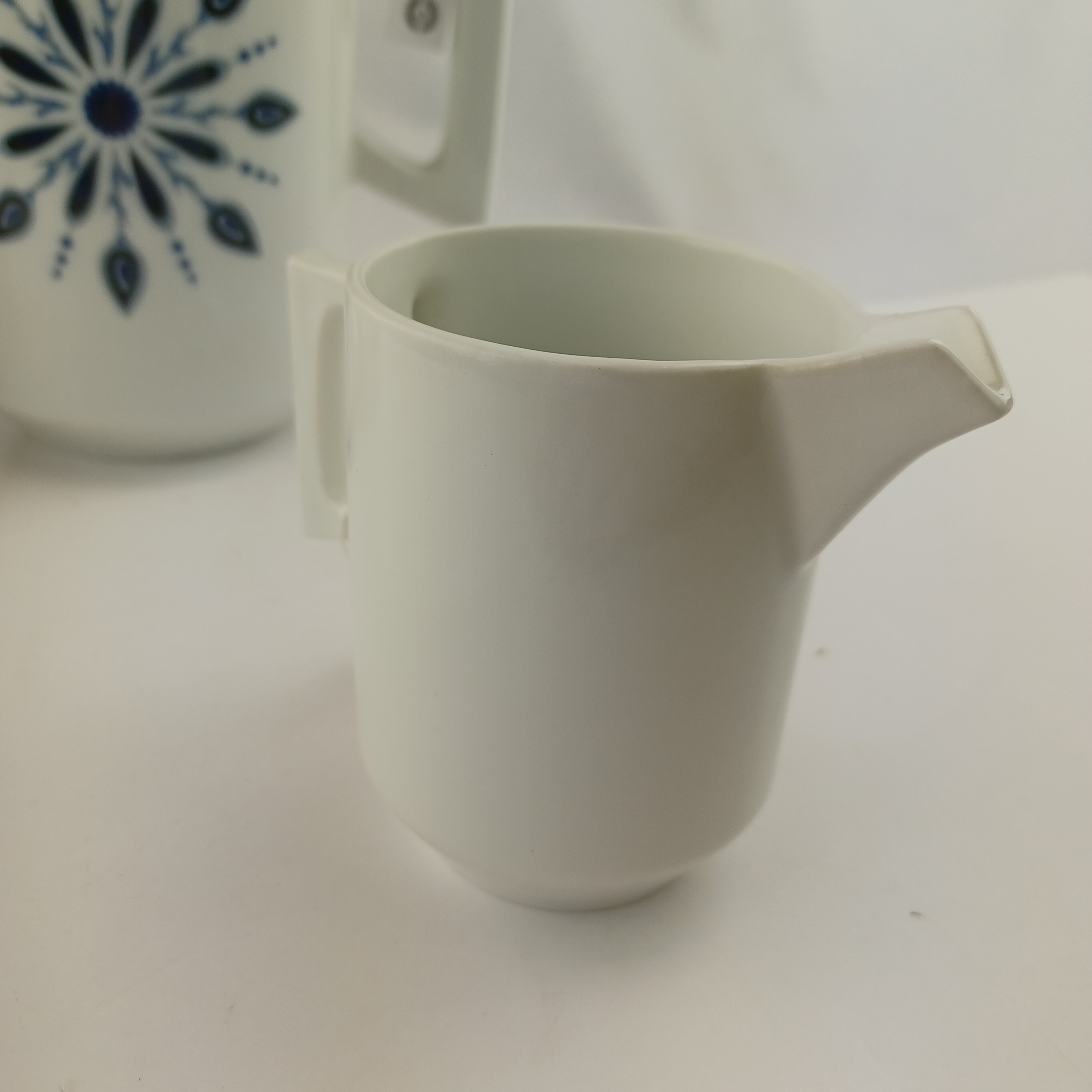 Voir photo 6 de Set de thé avec la théière le pot à sucre et le pot à lait Masse Surget A.A porcelainiers de France Mehun au décor inaltérable, en porcelaine blanche à motif fleuri et géométrique bleu Set de thé avec la théière le pot à sucre et le pot à lait Masse Surget A.A porcelainiers de France Mehun au décor inaltérable, en porcelaine blanche à motif fleuri et géométrique bleu Très bon état reconditionné photo 6