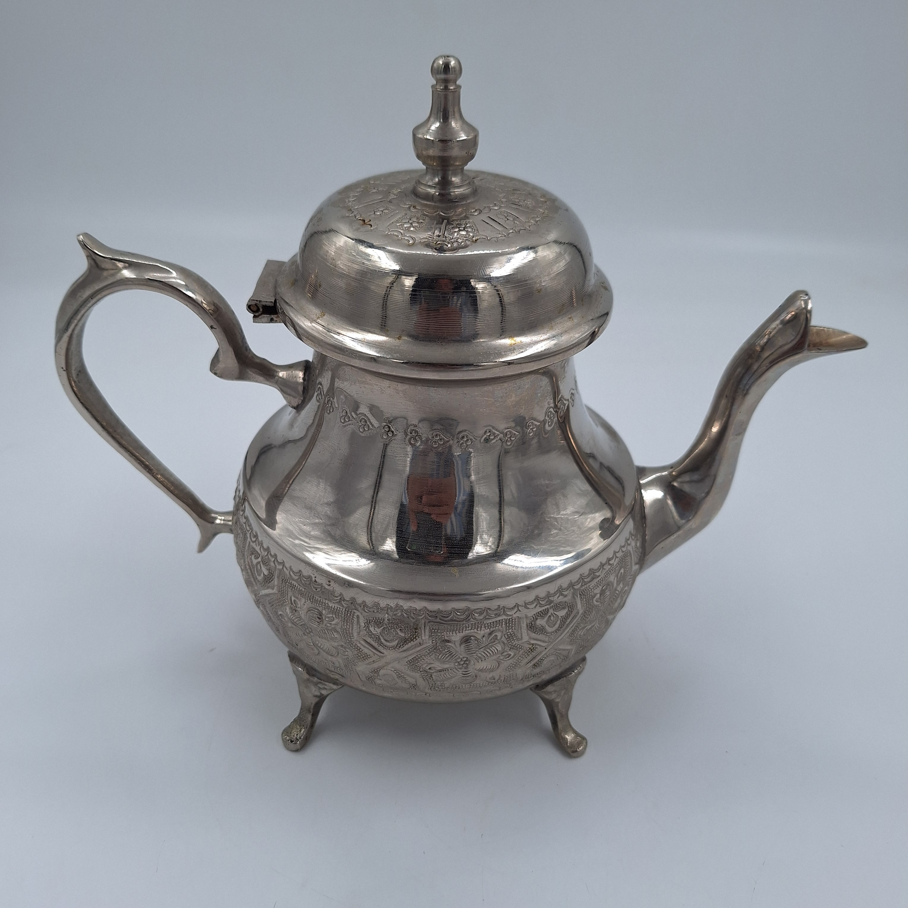 Voir photo 2 de Théière marocaine. Inox. Ciselé sur la base et le couvercle. Estampillée dessous. Théière marocaine. Inox. Ciselé sur la base et le couvercle. Estampillée dessous. Très bon état reconditionné photo 2